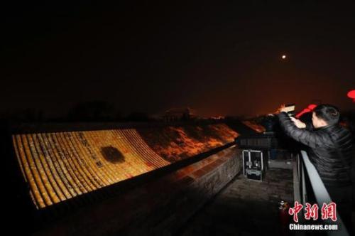 资料图：2月19日晚，以艺术灯光形式投影于古建屋顶上的《清明上河图》。中新社记者 杜洋 摄