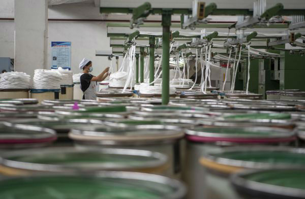  7月27日，工人在江苏南通海安市曲塘镇一家纺织企业的车间工作。新华社发