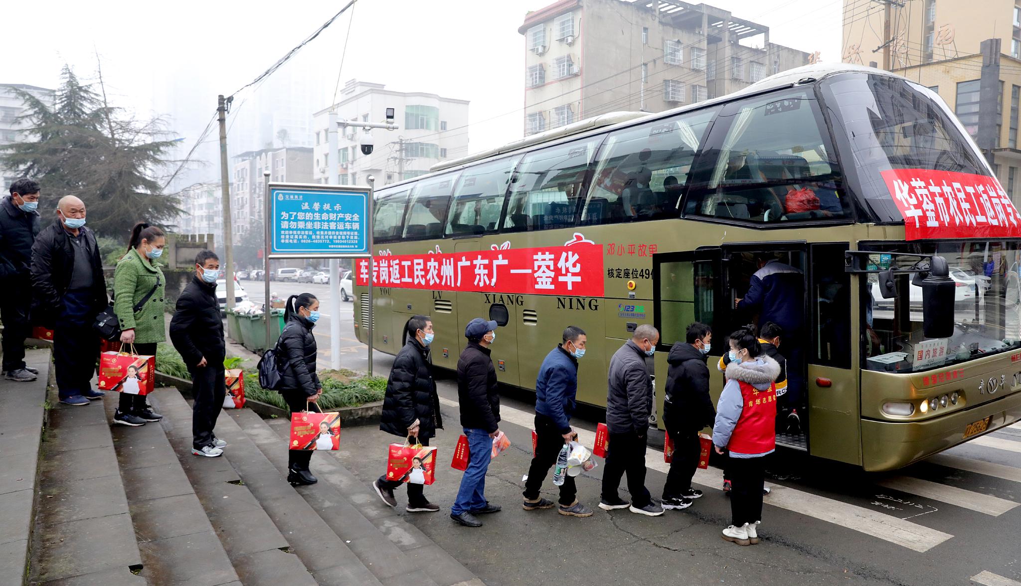 2022年春节，四川华蓥市的在外务工人员登上前往广州的返岗专车 / 视觉中国